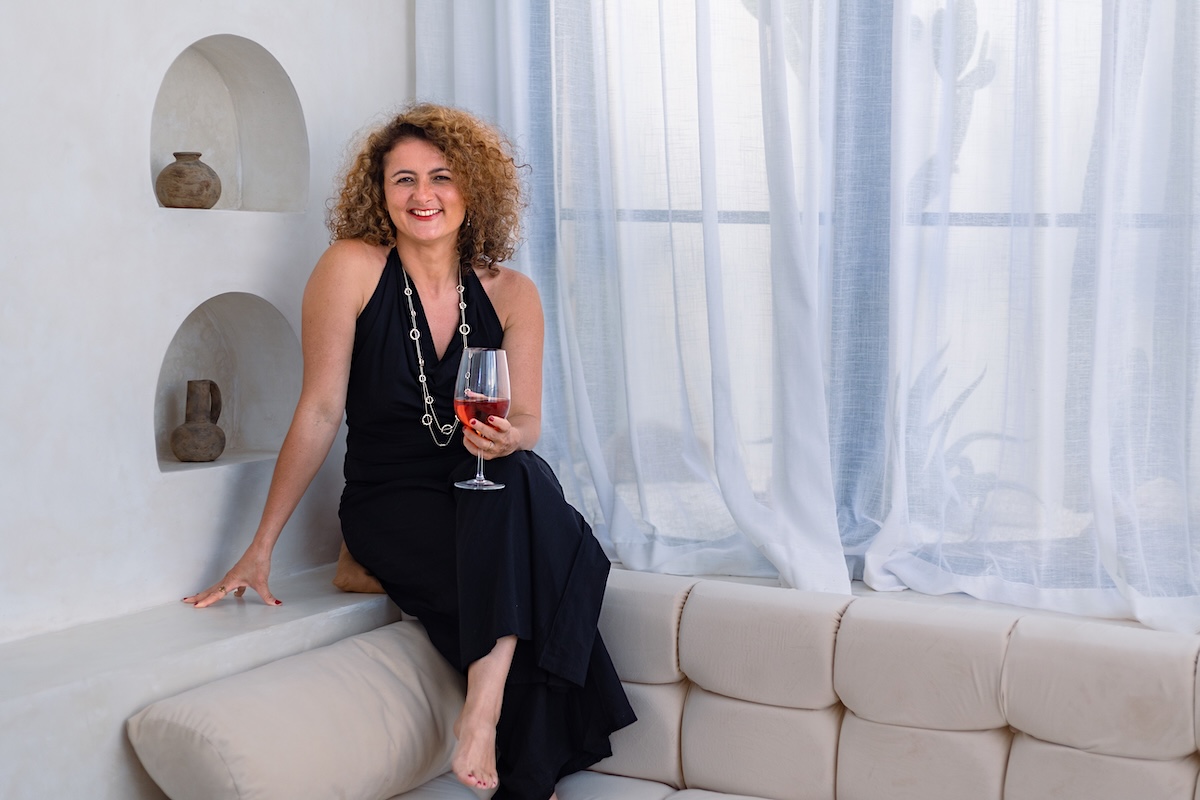 Dijan laughing on a plaster bench with rosé