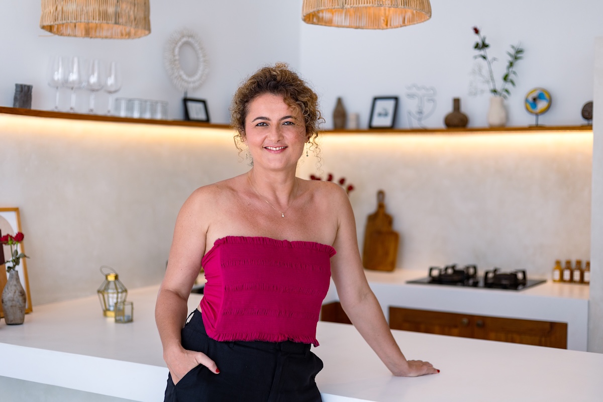 Dijan smiling in the kitchen, magenta top